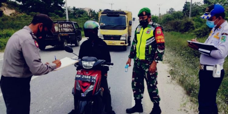Village Guidance Officer of Sub-District Military Command 03 / Siak Security at the Covid-19 Monitoring Post