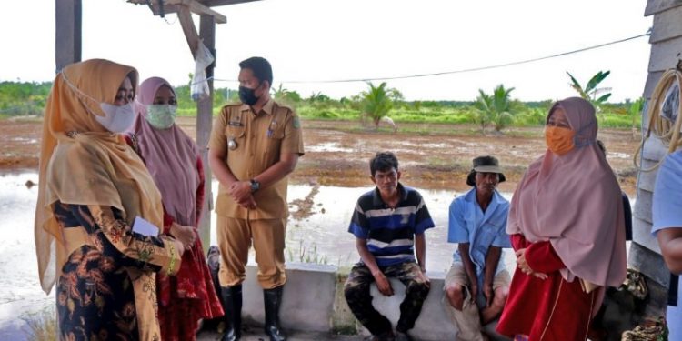 The Head of Family Welfare Empowerment of Siak Regency, Rasidah Alfedri Distributes Basic Food Aid at Koto Gasib