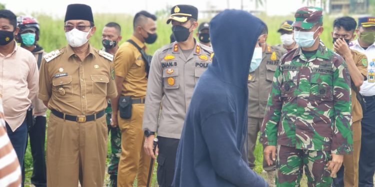 Violating the Health Protocol, Residents Asked to Clean the Cemetery Directly Supervised by the Regent of Indragiri Hilir